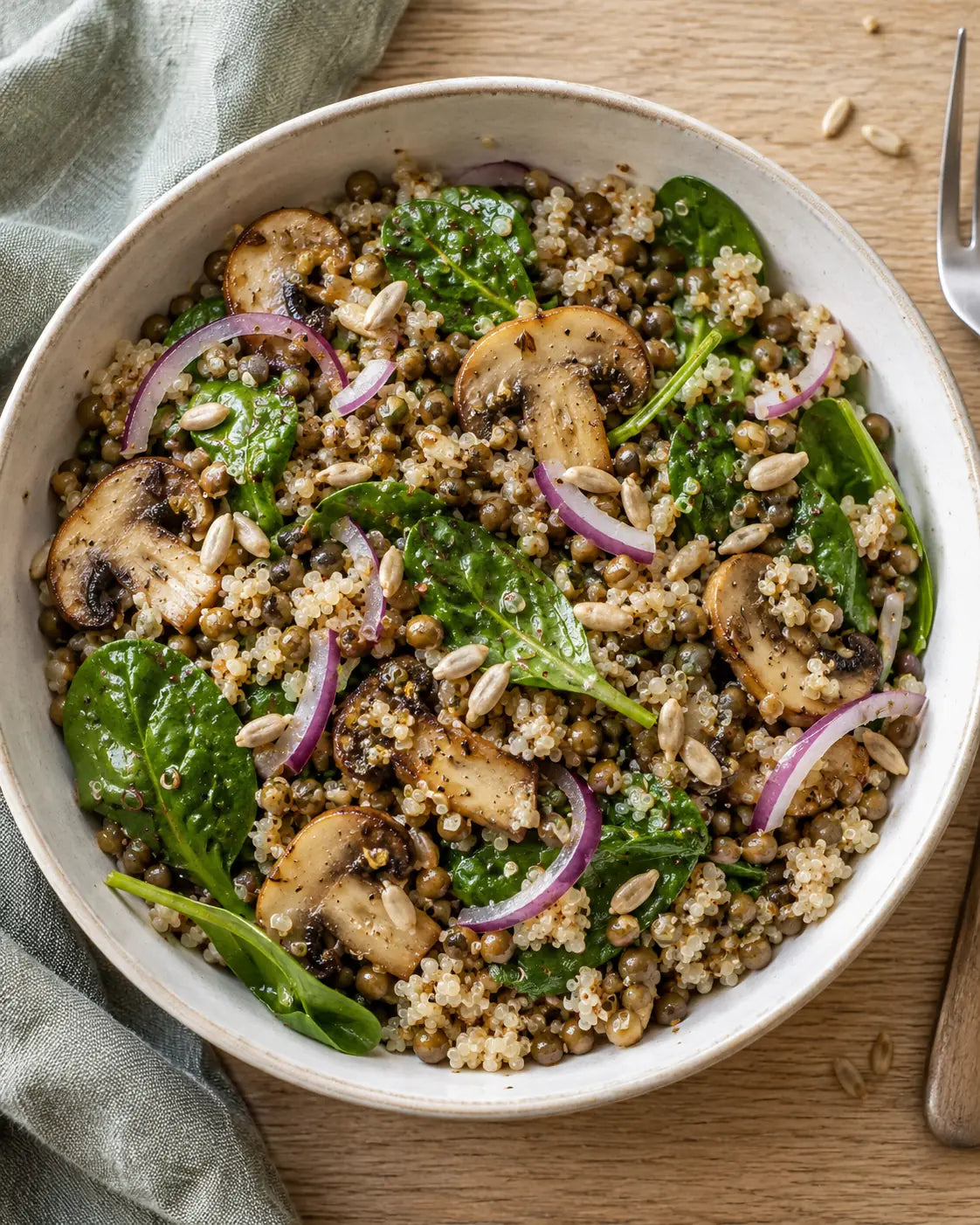 Bowl mit Linsen, Quinoa, gebratenen Champignons, Babyspinat und Sonnenblumenkernen