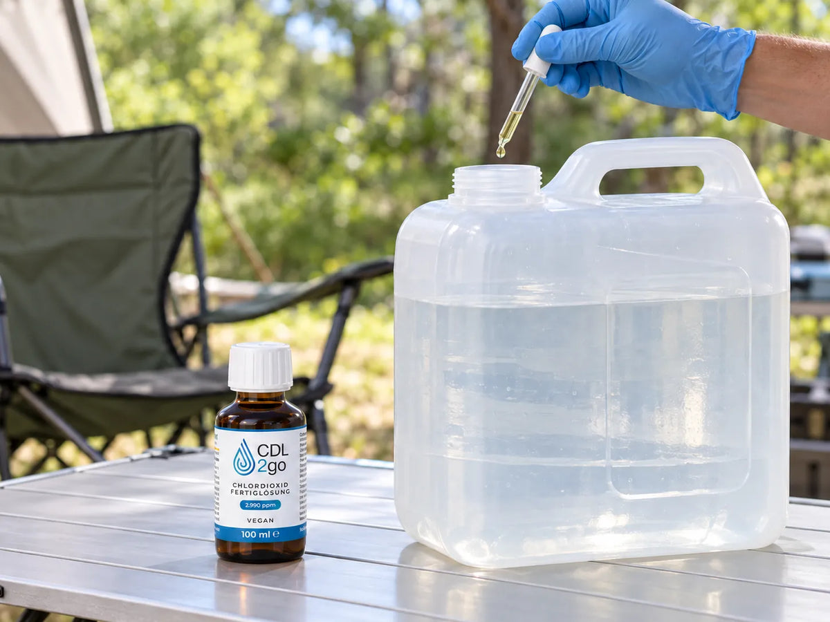 CDL2go 100 ml bottle, next to it a gloved hand drips the solution into a water jerrycan with the pipette