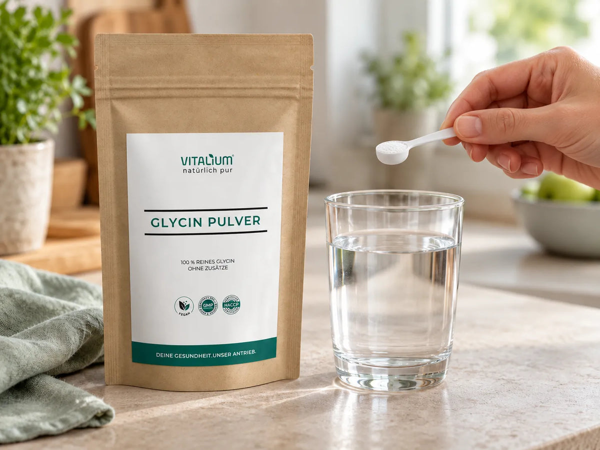 Glycin Pulver Beutel, daneben ein Messlöffel mit Pulver über einem Glas Wasser