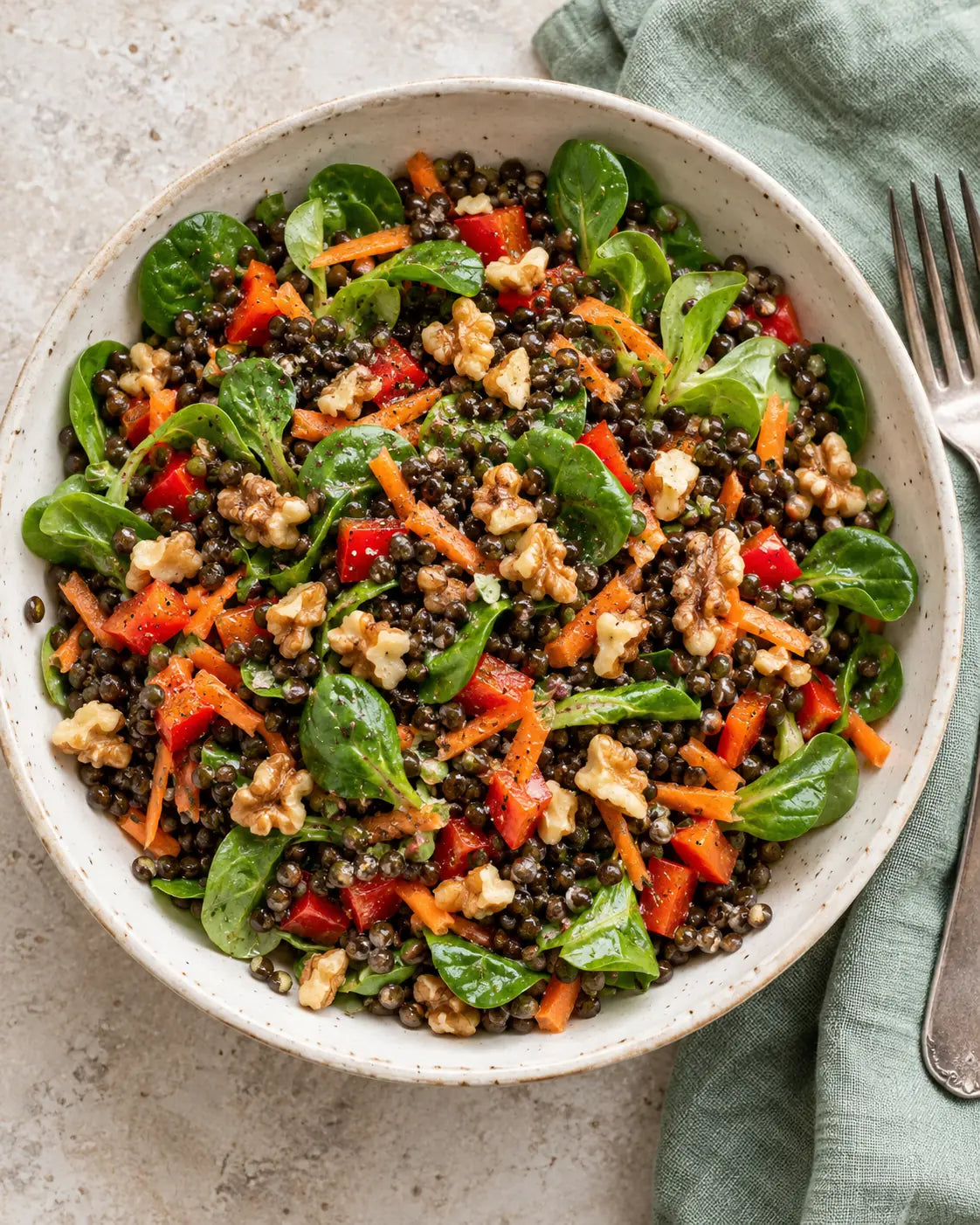Bowl mit Linsen, Walnüssen, Paprika, Karotten und Feldsalat
